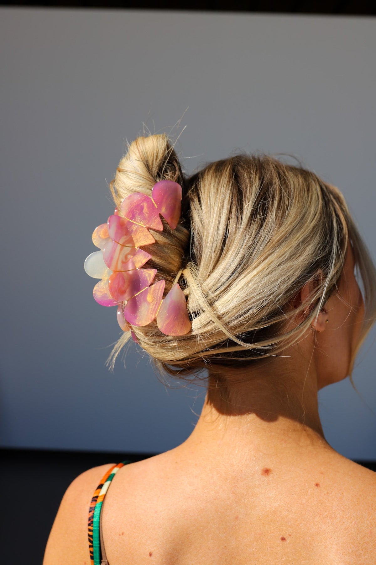 Hair claw clip with layered heart petals in pastel pink on blonde bun