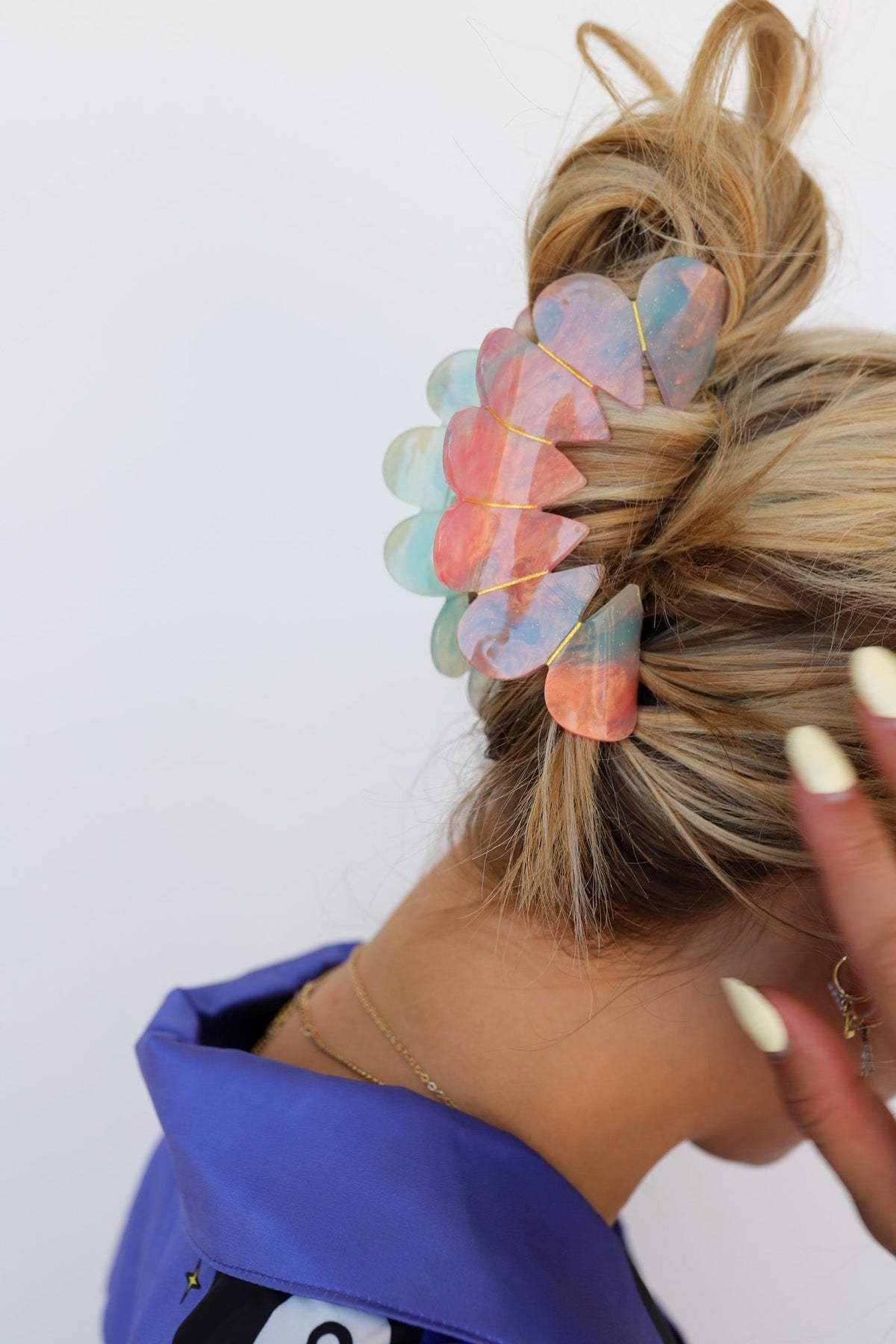 Heart-shaped hair claw clip in multicolor pastel tones on blonde hair