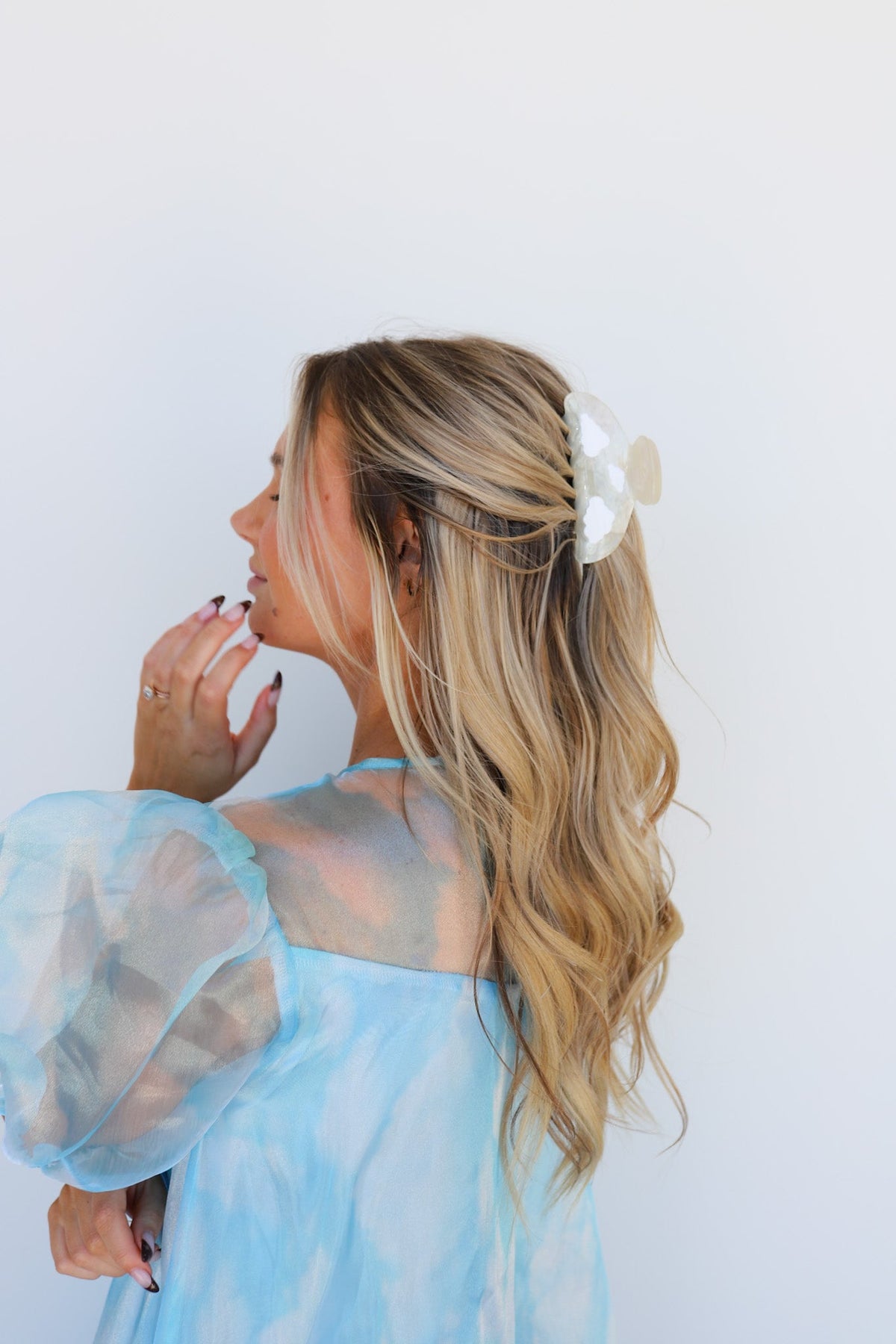 Blonde updo with white heart hair claw clip, paired with light blue dress