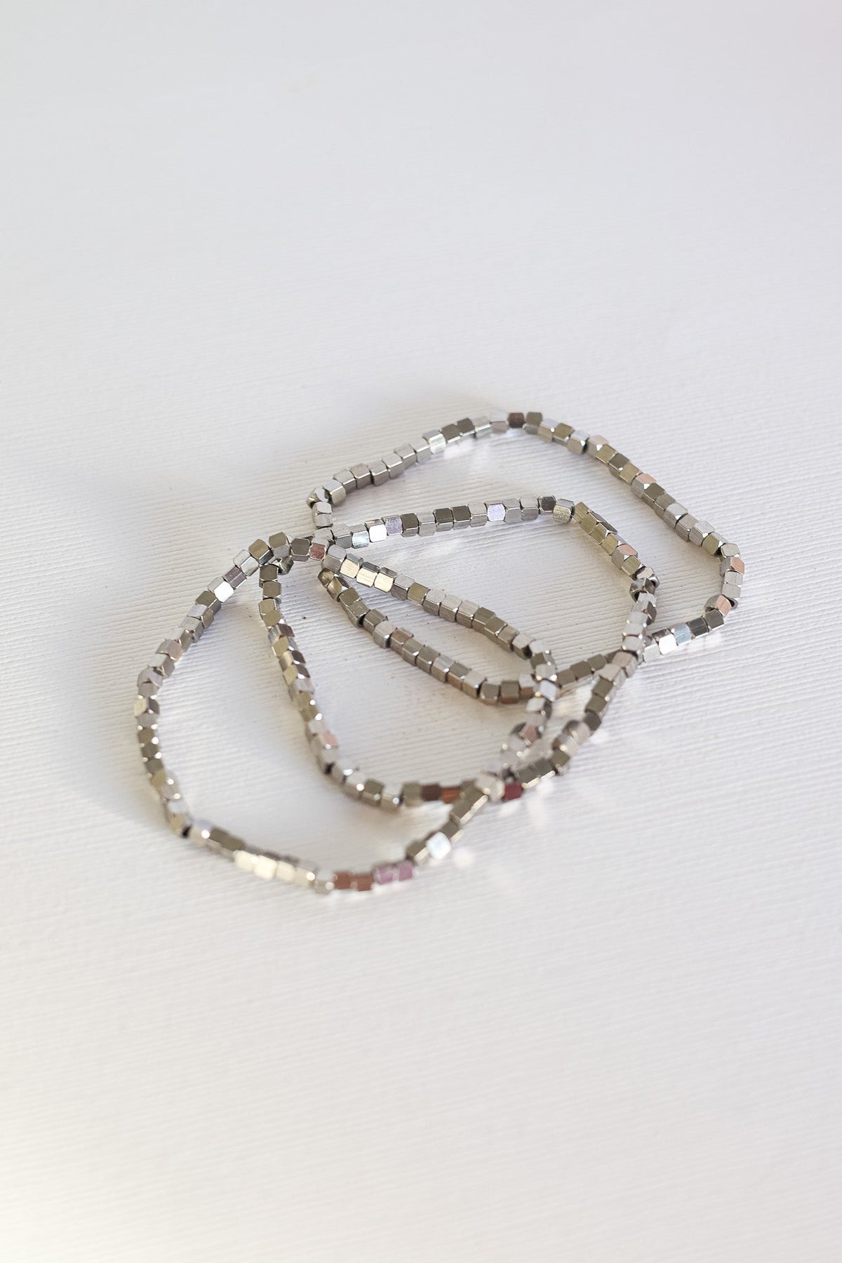 Ember silver-tone bracelets with small square beads, layered together
