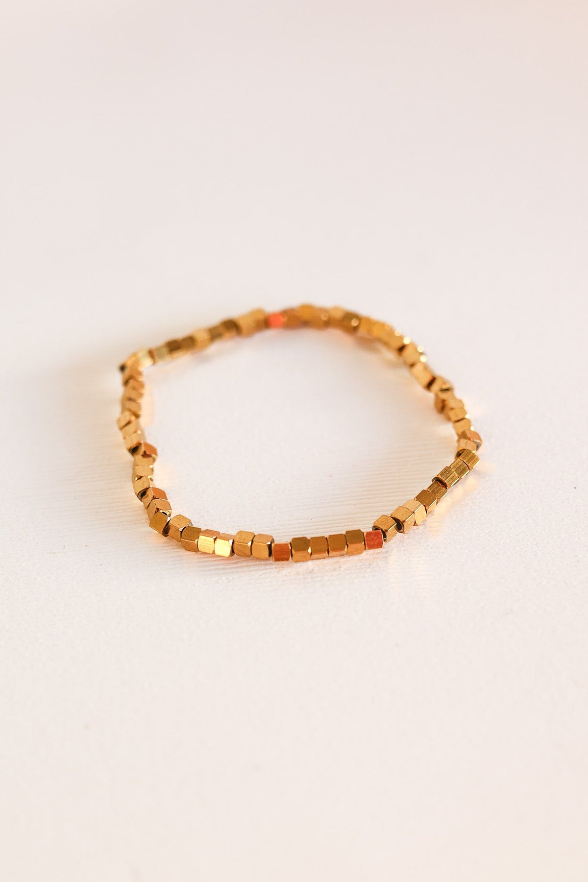 Single gold Ember bracelet made of small square beads