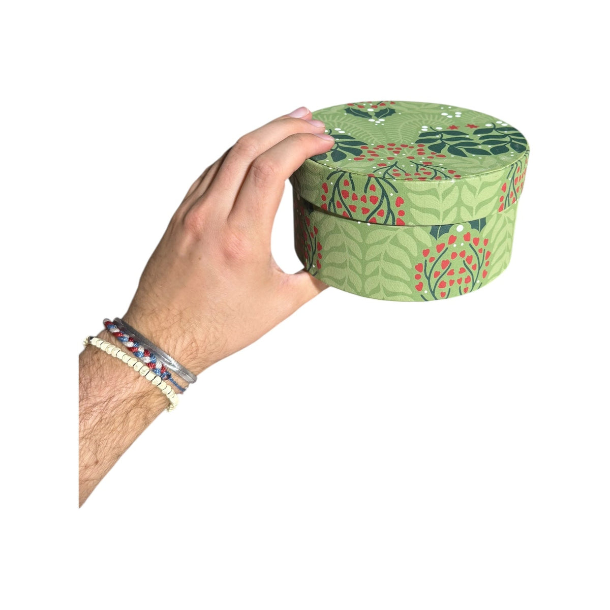 Round light-green botanical nesting gift box with leaf pattern and red berries, recycled paper