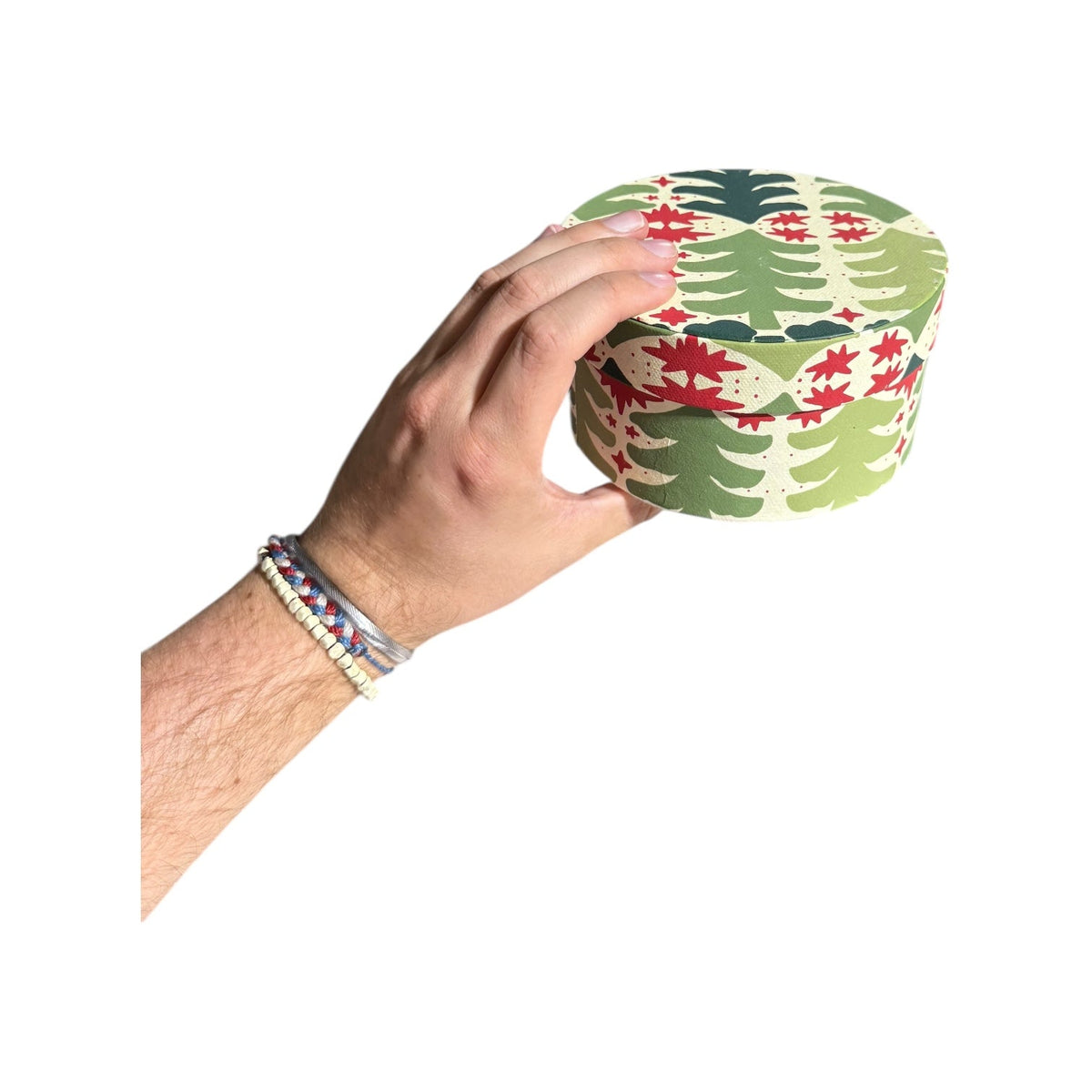 Round light-green botanical nesting gift box with red rosette and leaf pattern, handmade recycled paper
