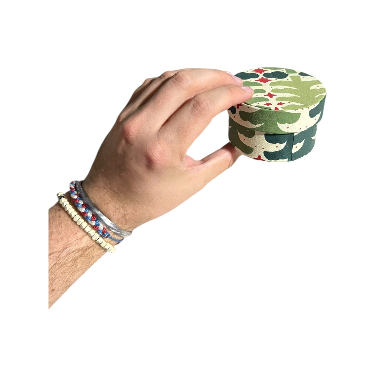 Round green botanical nesting gift box with leafy pattern and dark shapes, handmade recycled paper