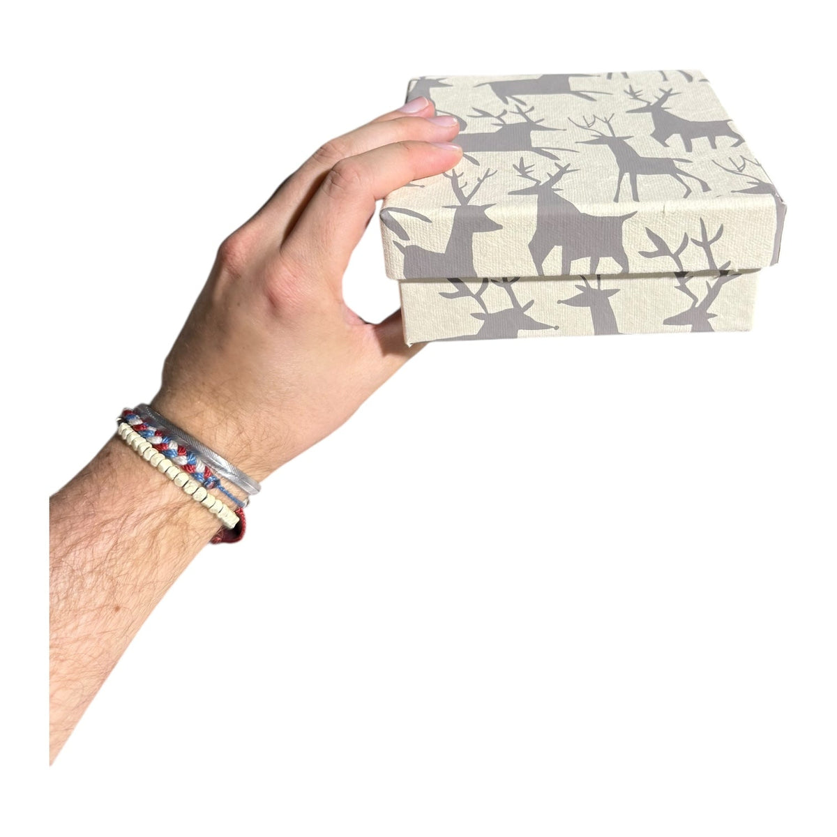 Square gift box with beige and gray reindeer, trees, and bird silhouettes