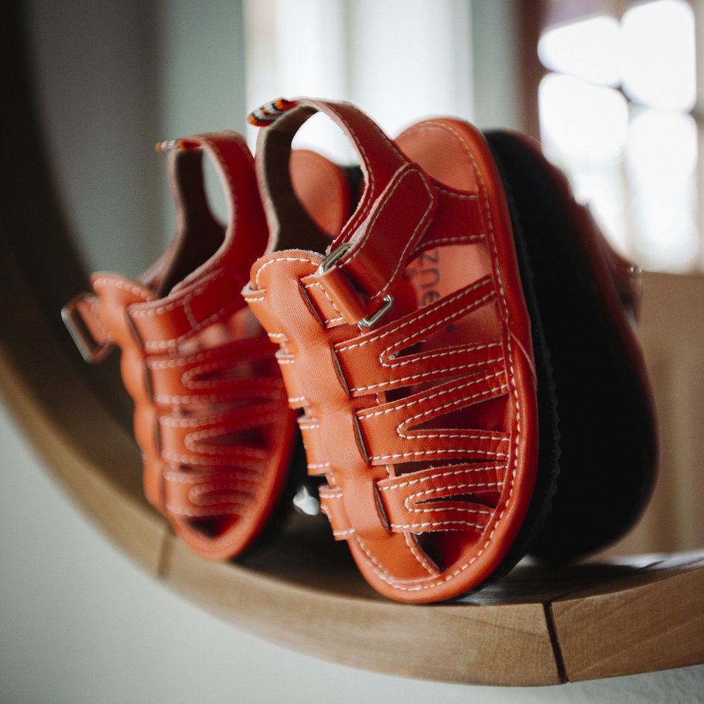 Orange barefoot sport sandals with adjustable hook-and-loop straps and stitched panels