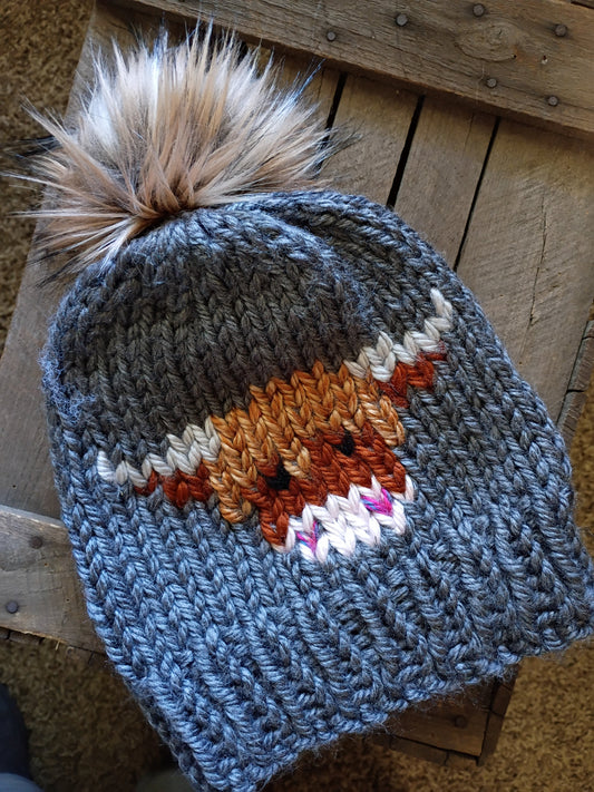 Charcoal knit beanie with tall faux-fur pom-pom and blue cow intarsia