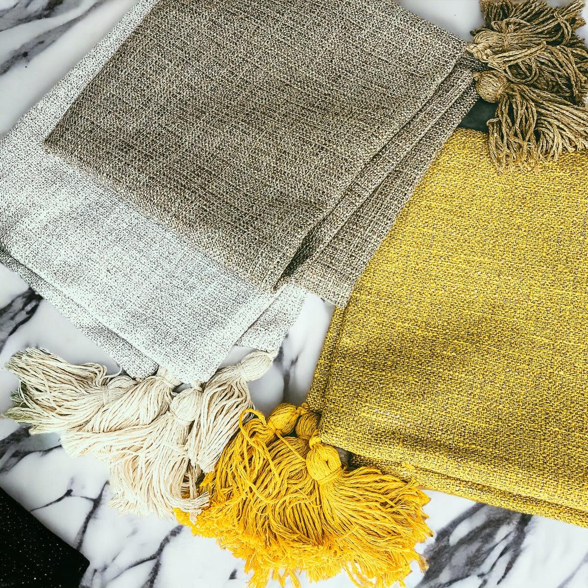 Set of textured pillow covers in olive, ivory, and mustard yellow with tassel fringe