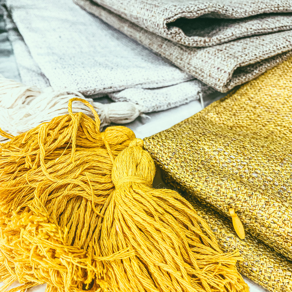 Mustard-yellow linen-look pillow case with chunky tassel fringe detail
