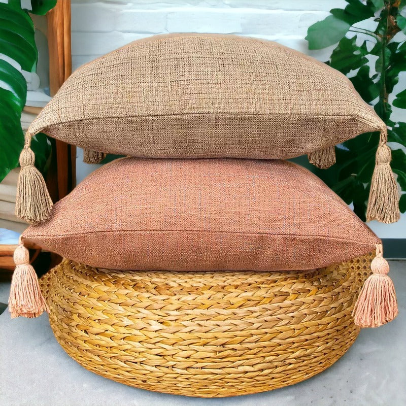 Square linen-look pillow cases in taupe and peach, each with tassel fringe