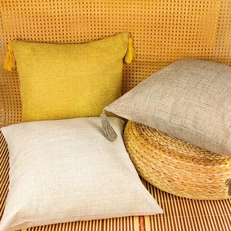 Linen-look pillow cases in yellow and light beige with tassel corner detail