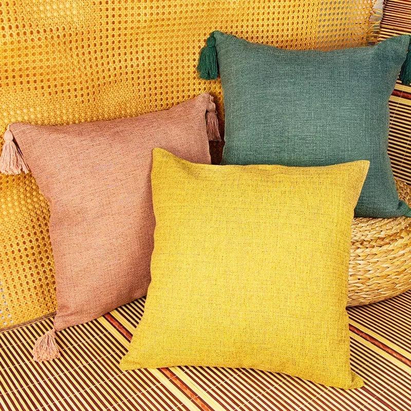 Three square pillow covers in dusty rose, bright yellow, and deep green
