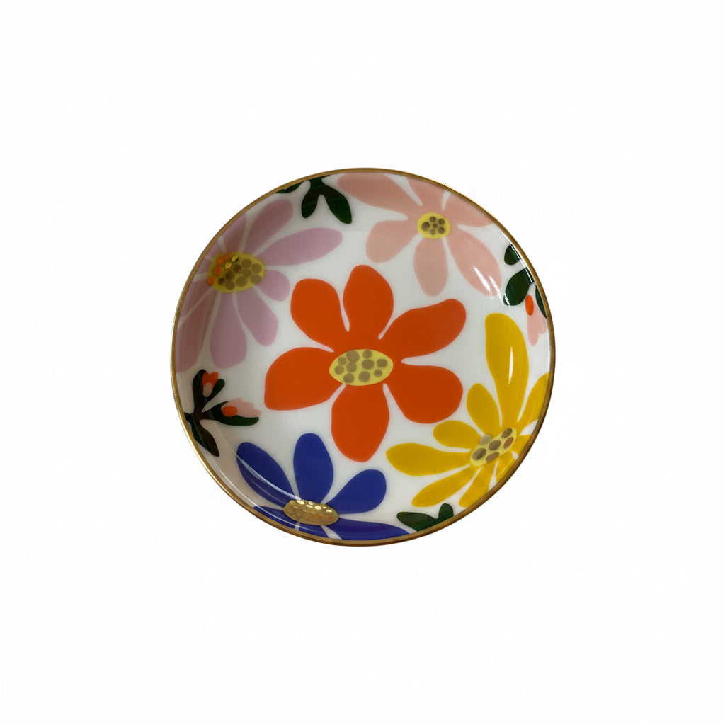 Round porcelain dice dish with colorful floral print and gold-tone rim