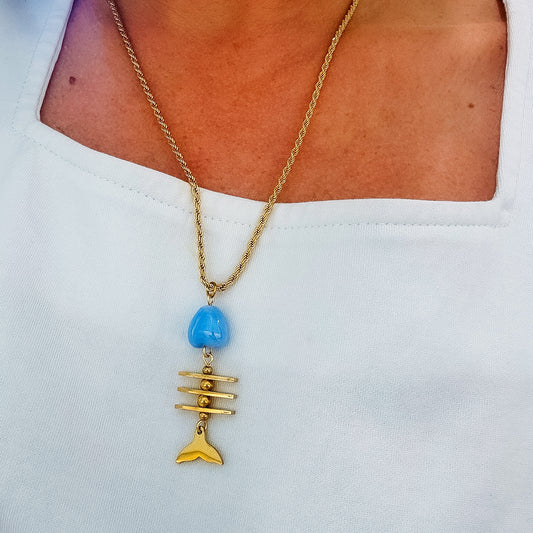 Gold chain necklace with blue bead, bar detail, and fish pendant