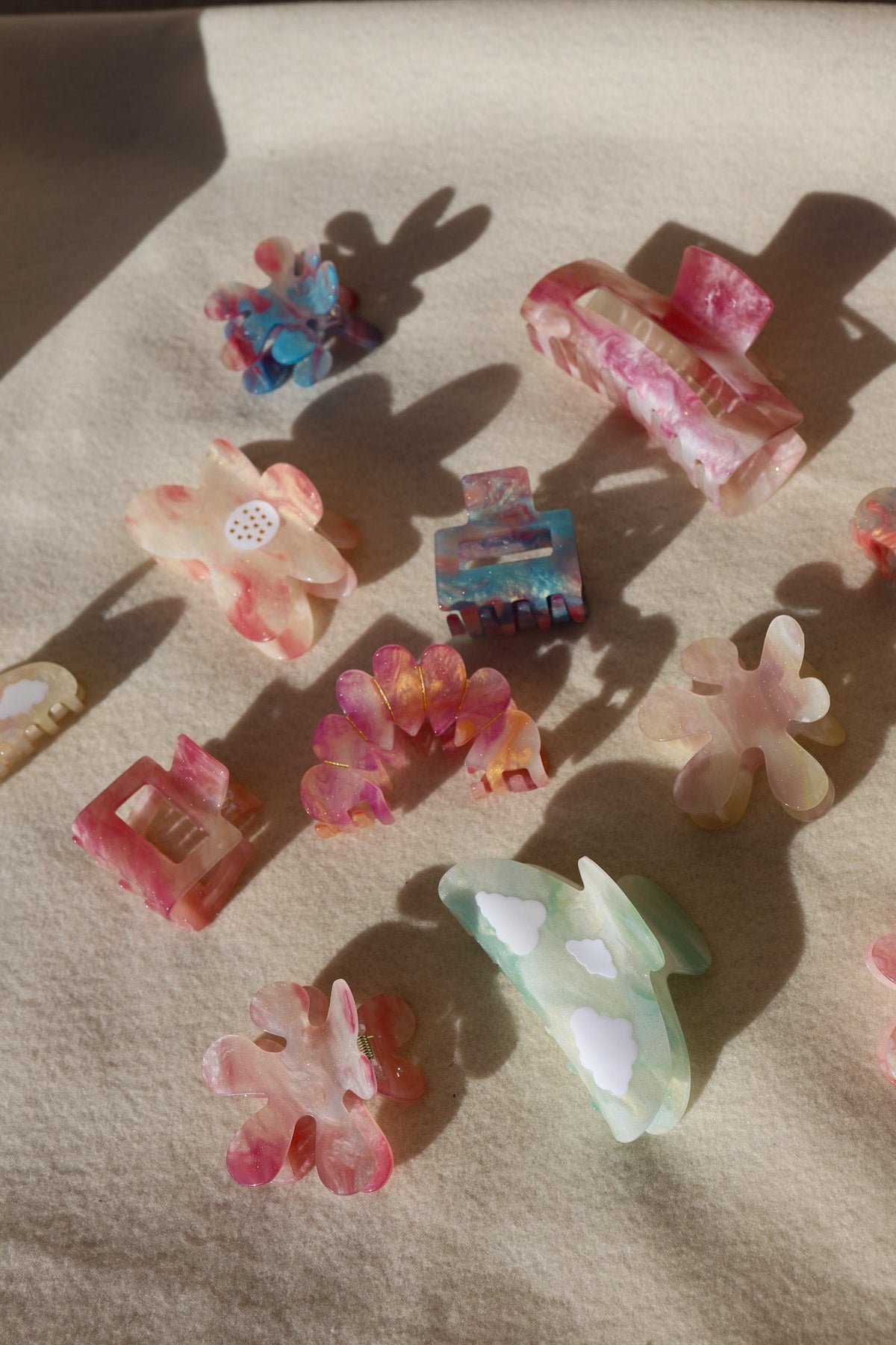 Set of assorted pastel hair claw clips arranged on fabric surface