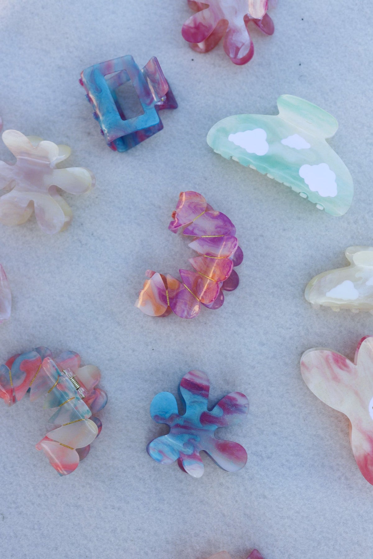Assorted translucent hair claw clips in pastel colors, scattered