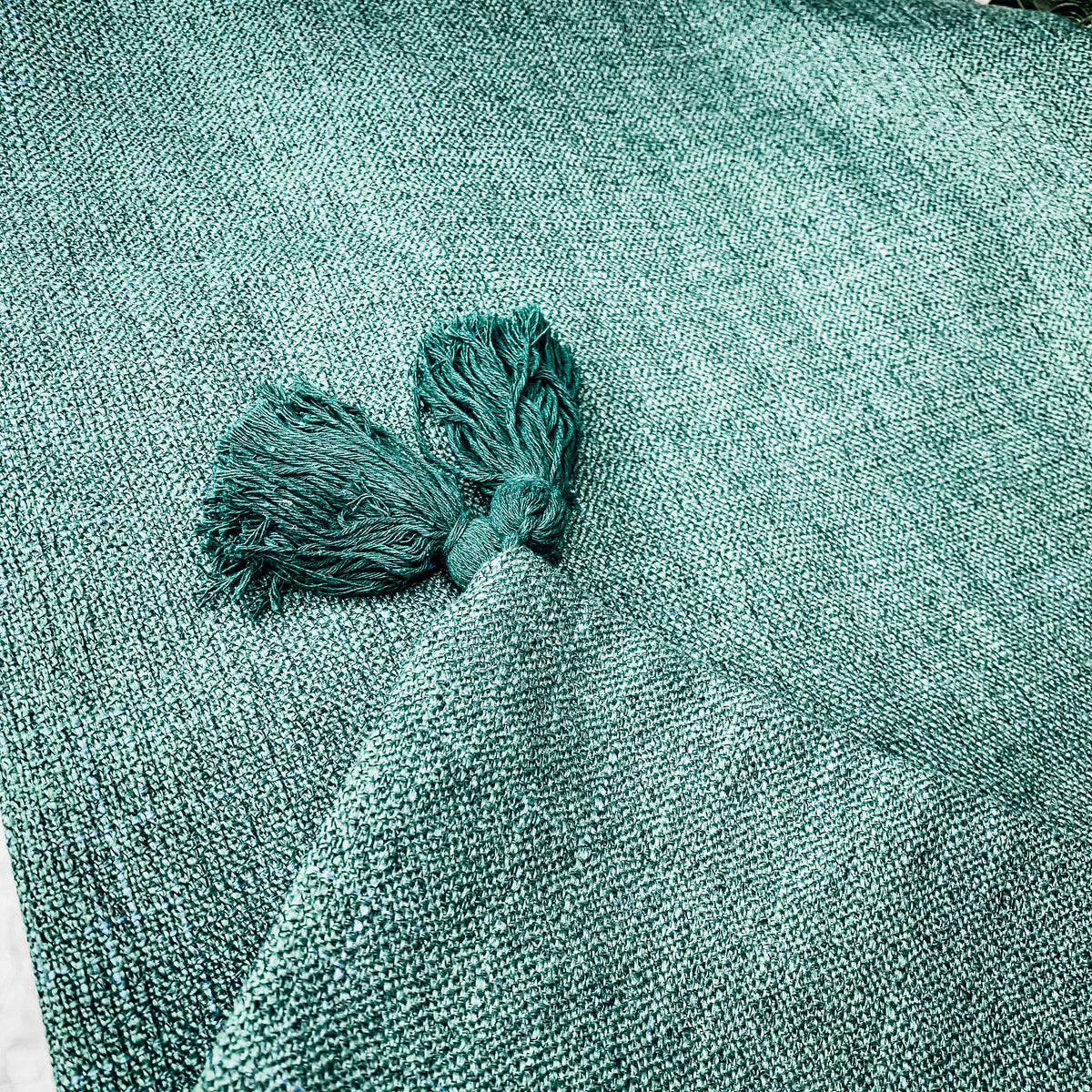 Teal-green linen-look pillow case corner with matching tassel fringe