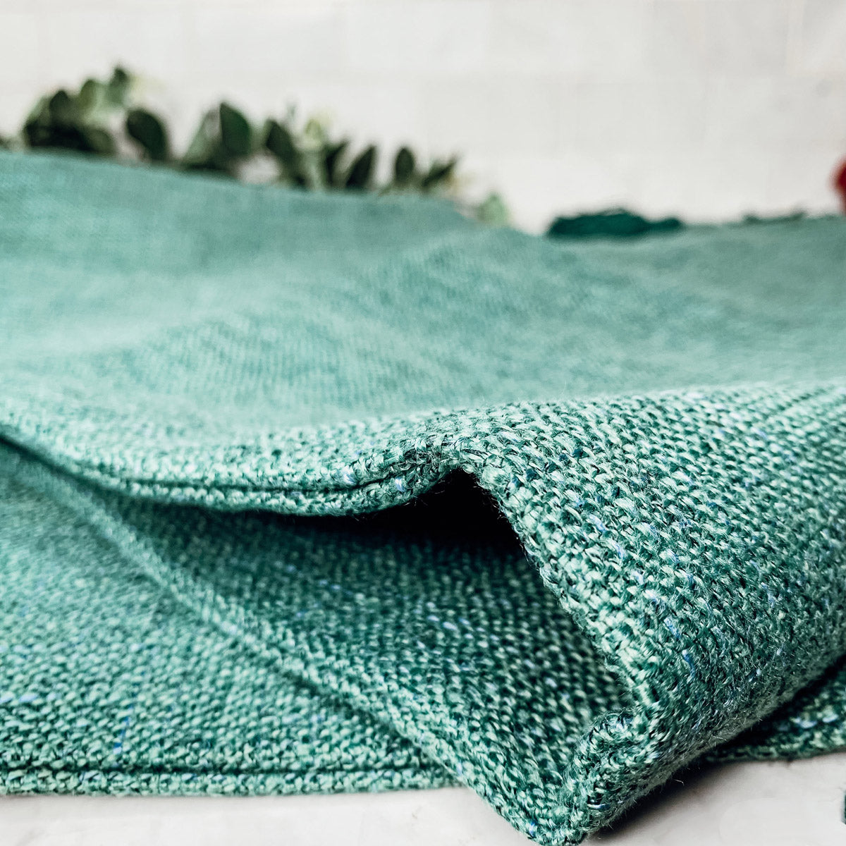 Boho cottage pillow case fabric in teal green with visible woven texture.