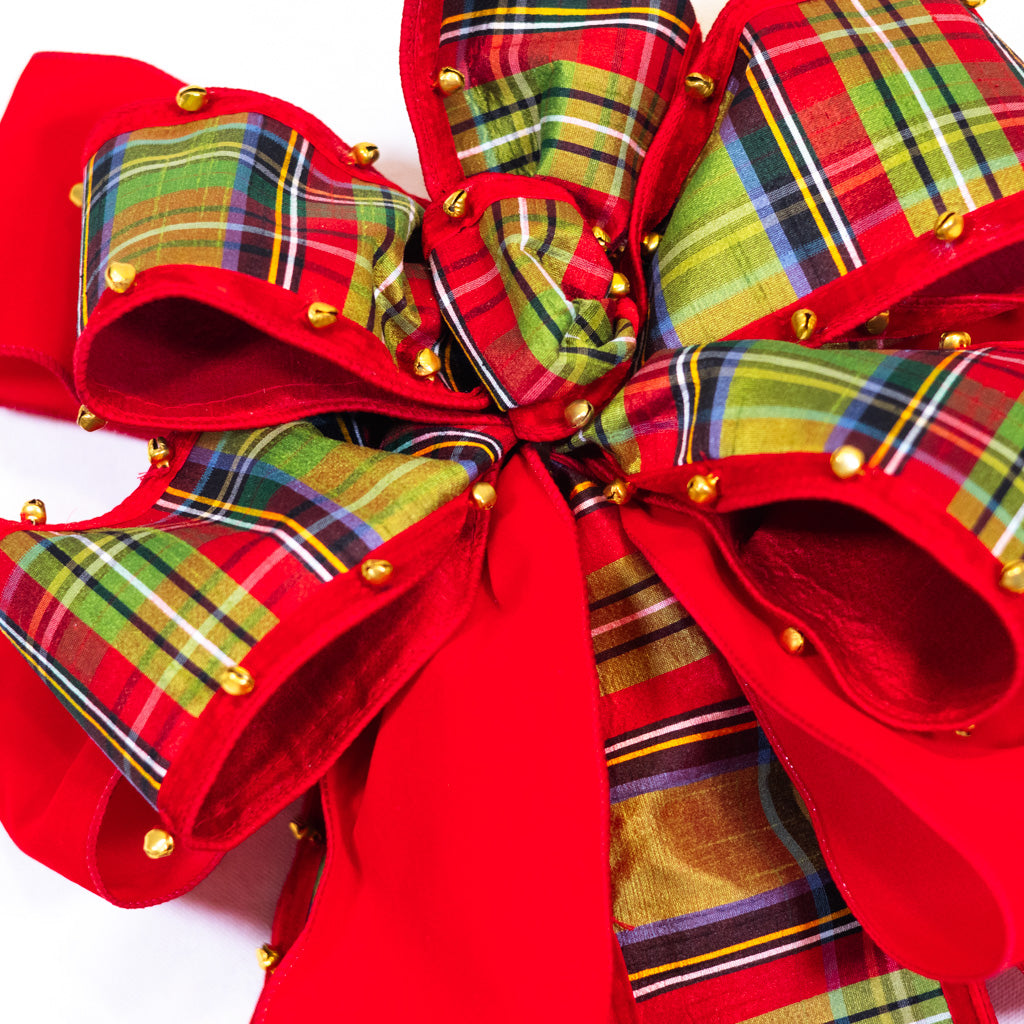 Close-up plaid ribbon bow with red loops and gold stud accents