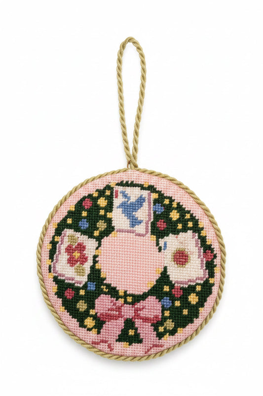 Needlepoint mahjong wreath ornament, round fabric with multicolor floral and blue figure, hanging loop