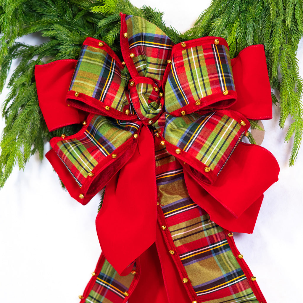 Large plaid ribbon bow with layered loops, gold studs, and red hanging tails