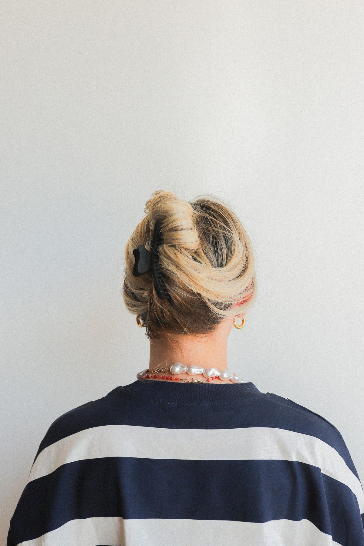 Wavy hair claw clipped in blonde hair bun, rear view
