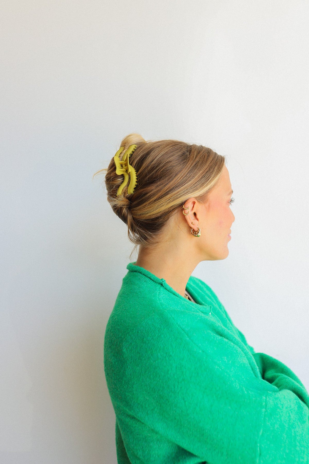 Yellow wavy edge hair claw clip holding blonde hair in a bun