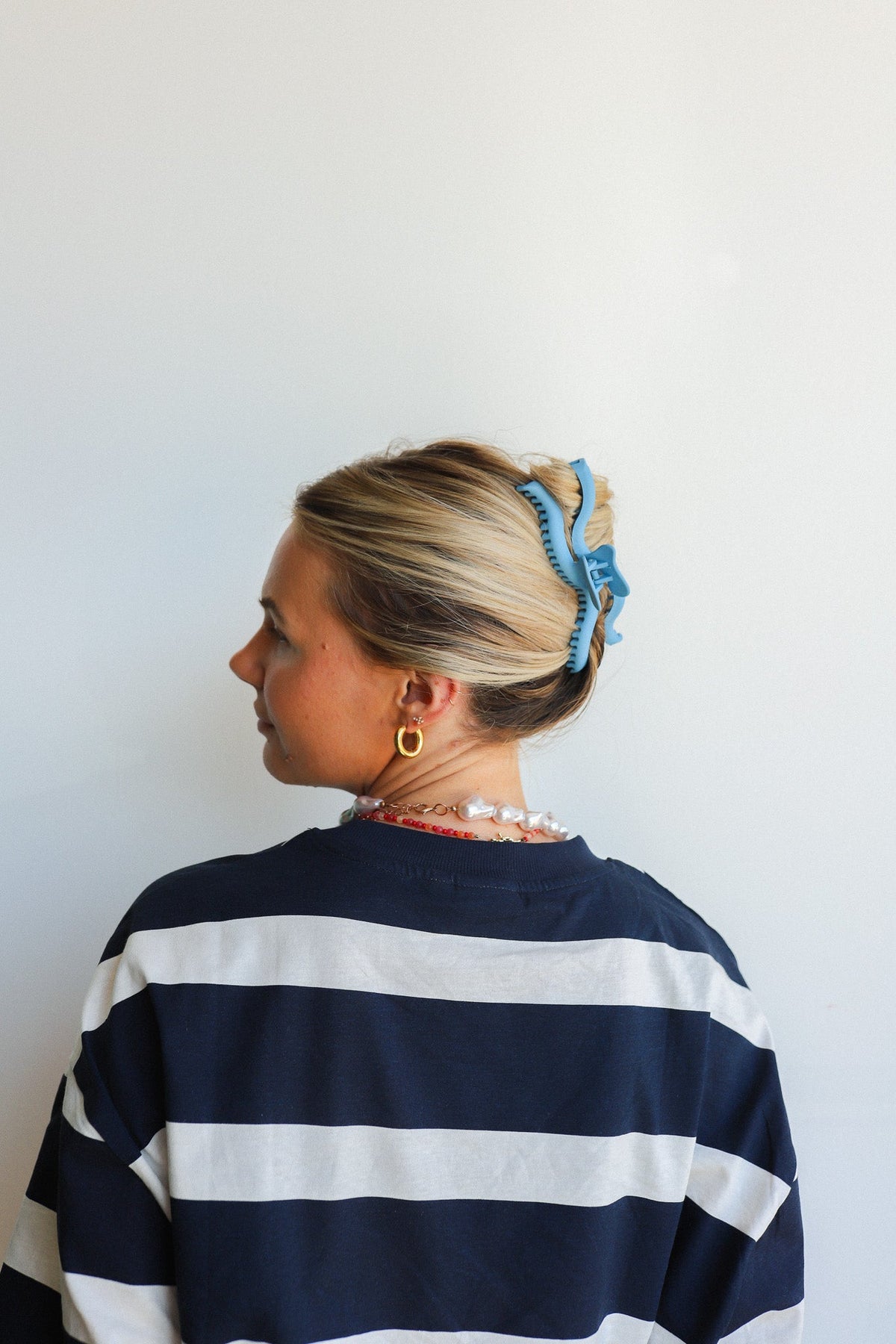 Wavy hair claw in dark blue clipped into blonde bun