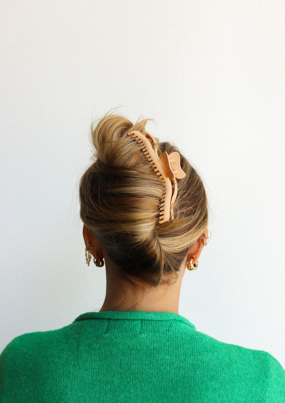 Orange-brown hair claw clip with curved comb teeth holding a bun.