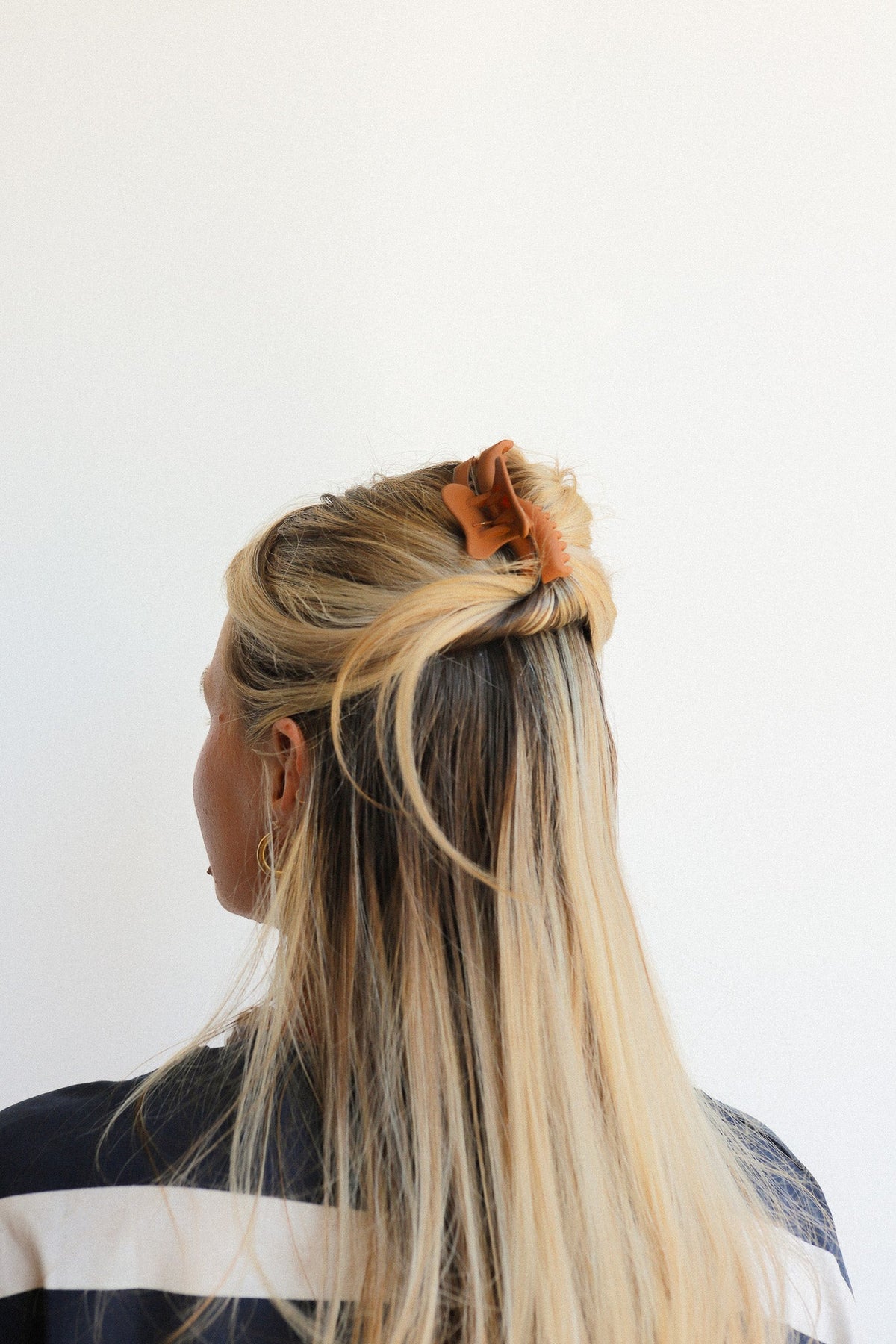 Orange wavy mini hair claw securing blonde hair up