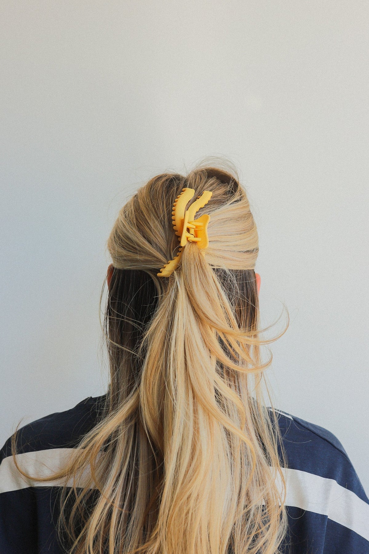 Wavy hold-them hair claw securing a bun on long blonde hair