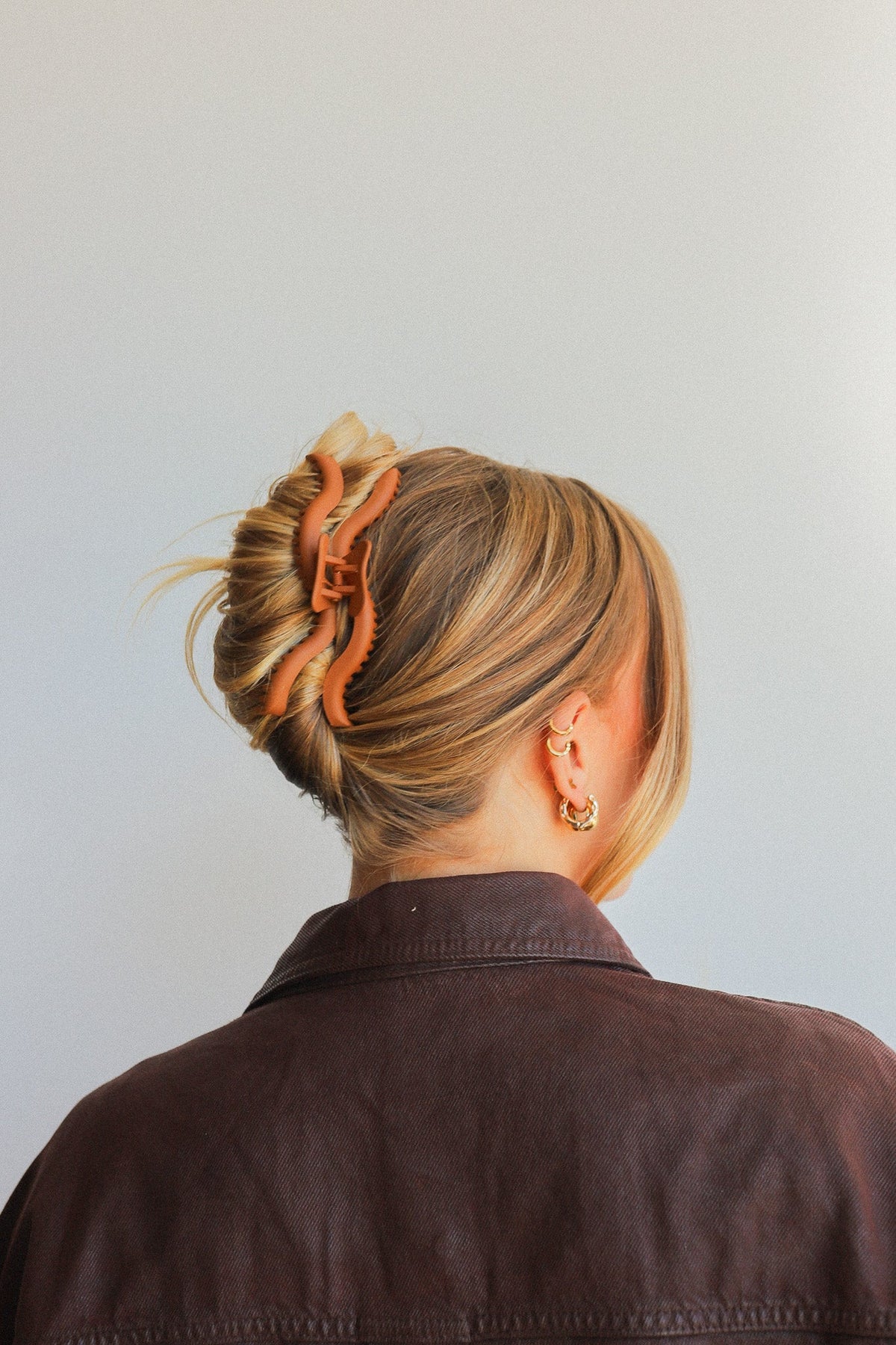 Brown hair claw clip with curved comb teeth for holding an updo bun.