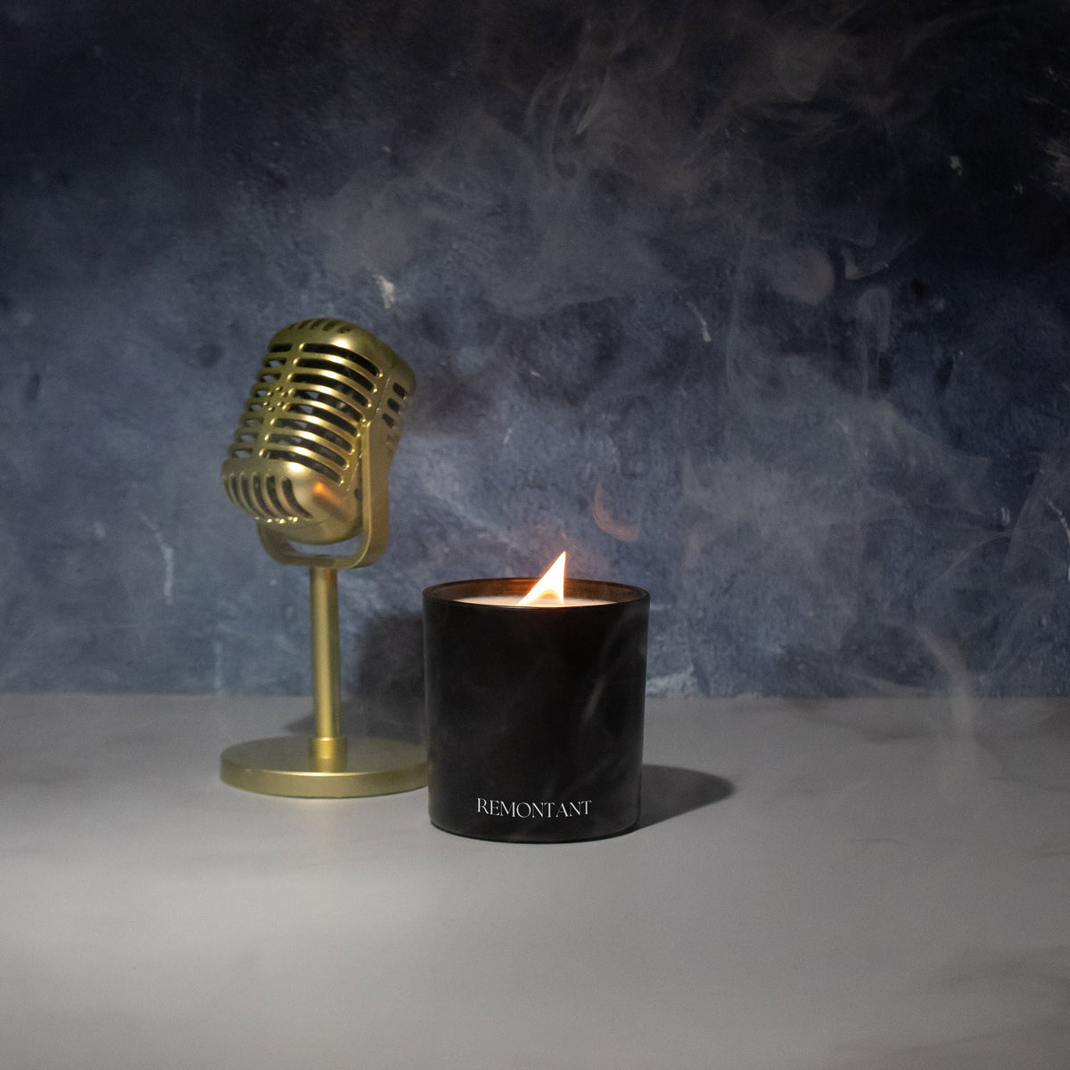 Black Remontant candle with a lit wick