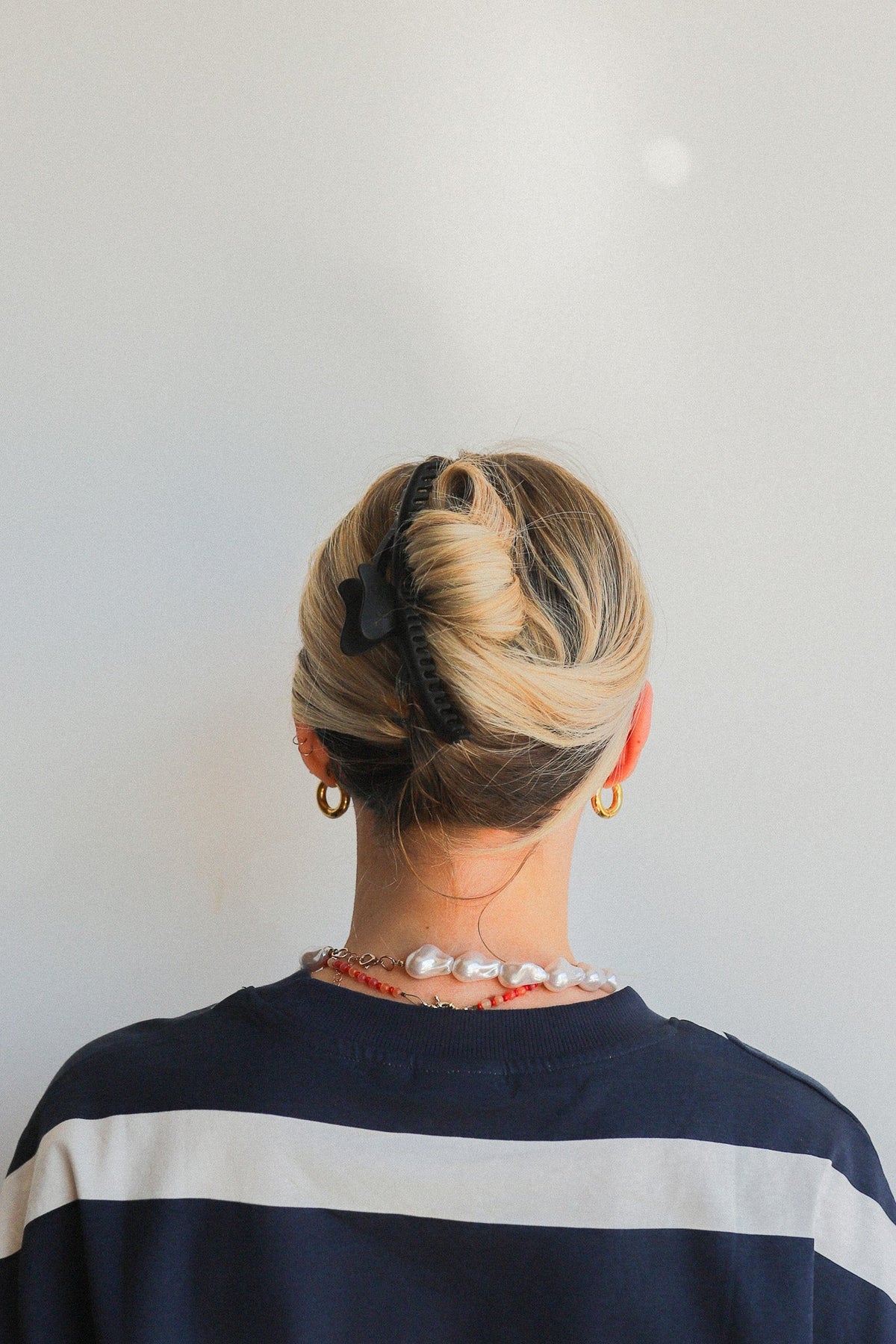 Black wavy claw hair clip securing a low bun