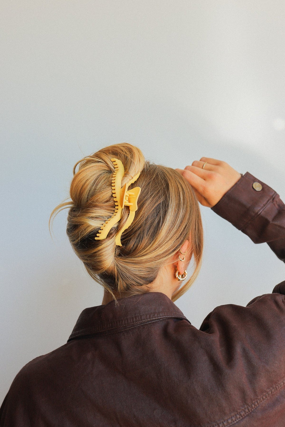 Golden wavy hair claw clip securing blonde hair in a bun