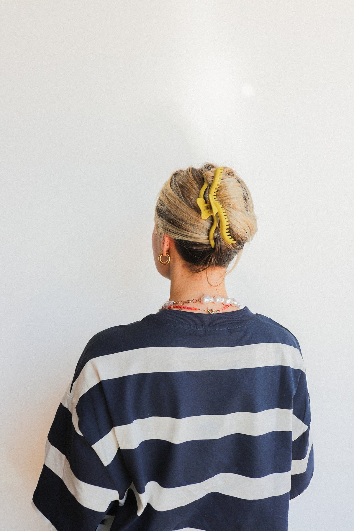 Gold-toned wavy hair claw clipped in hair, viewed from behind