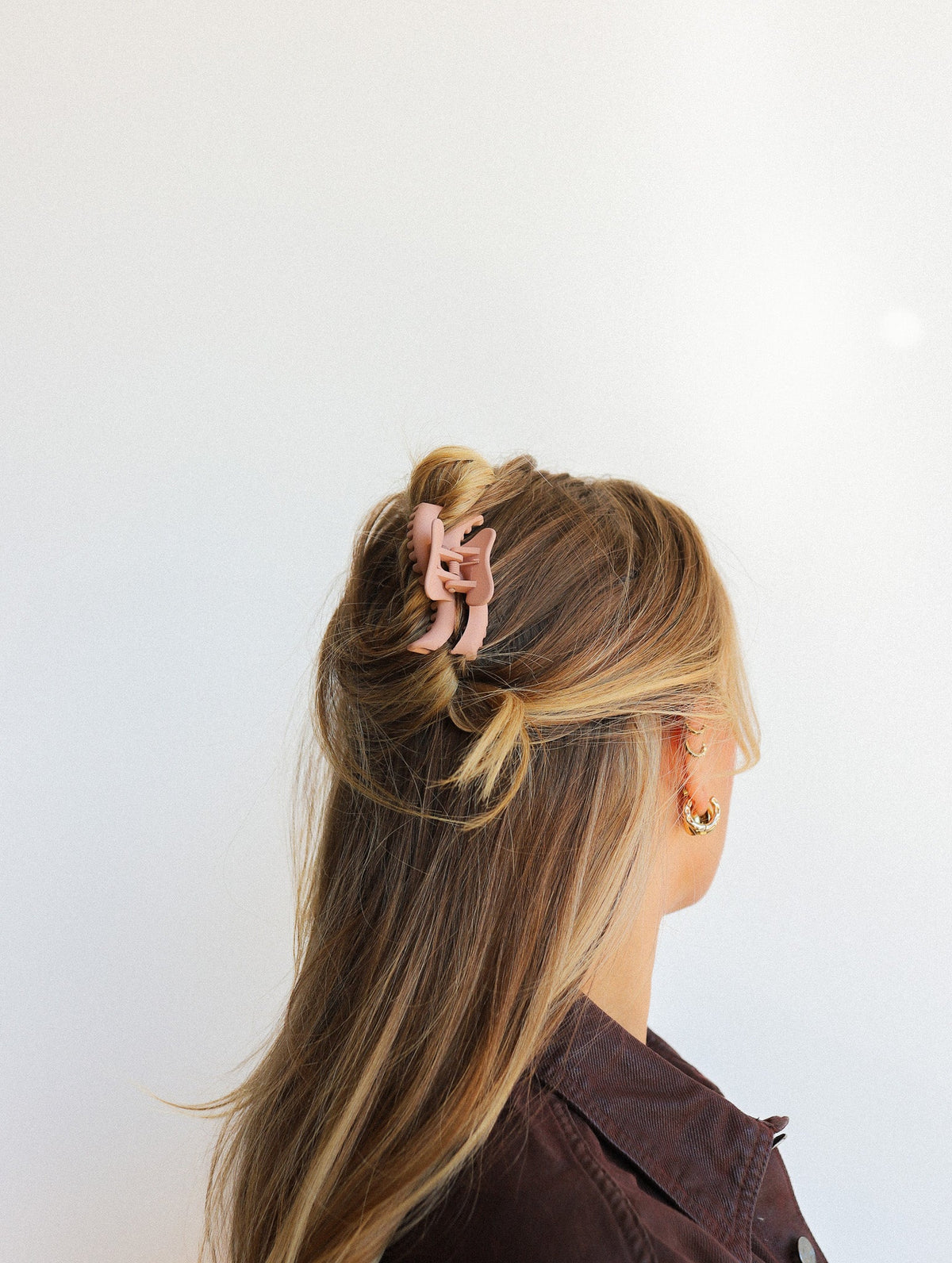Wavy mini claw hair clip in light rose, holds thick hair strands back.