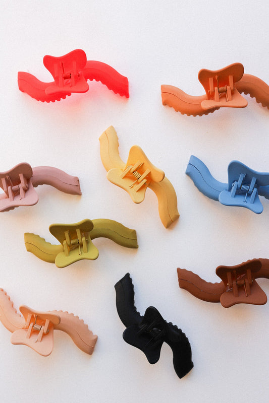 Assorted plastic hair claws in multiple colors, wavy sculpted design