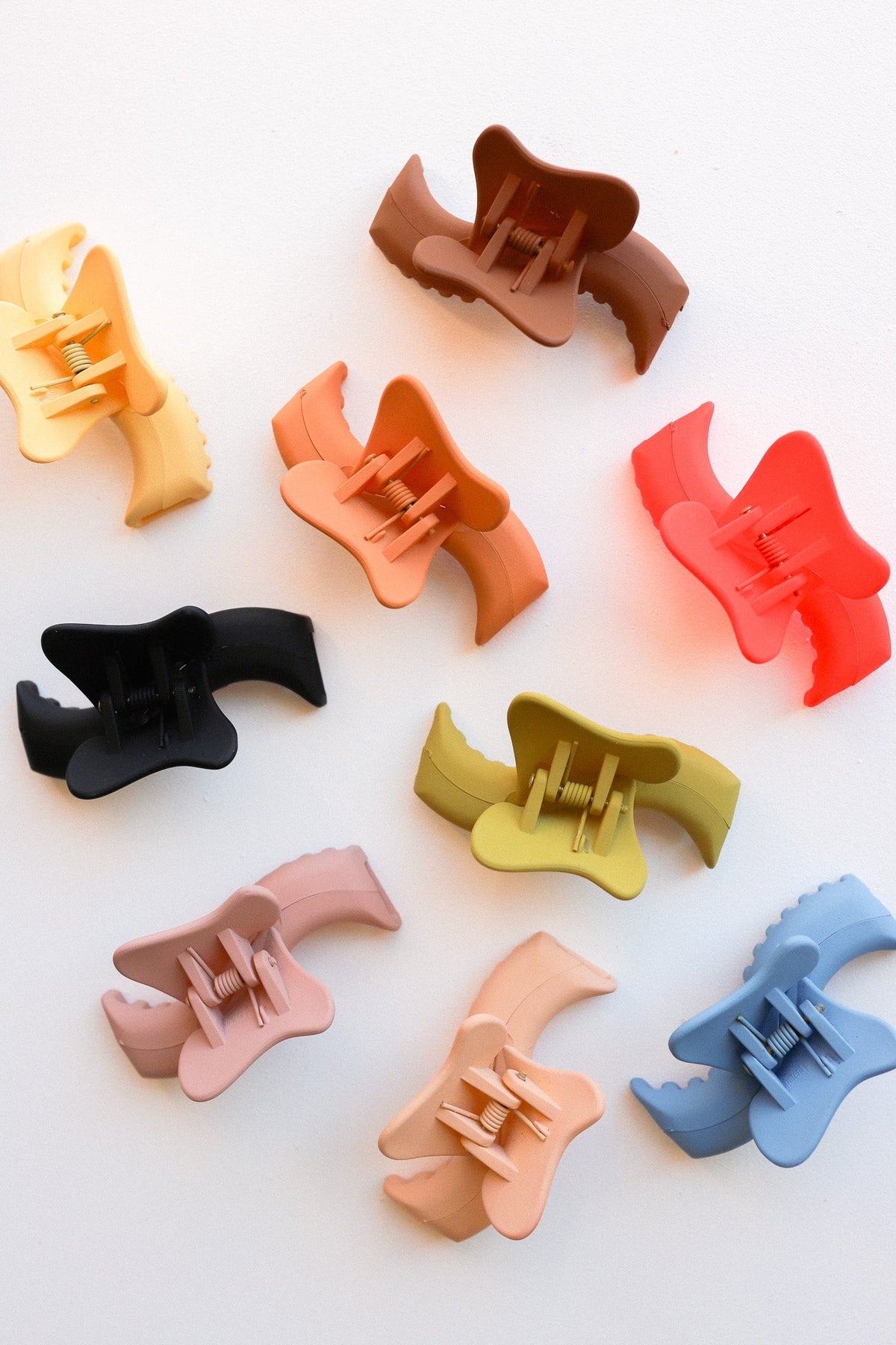 Assorted wavy mini hair claw clips in multiple colors.