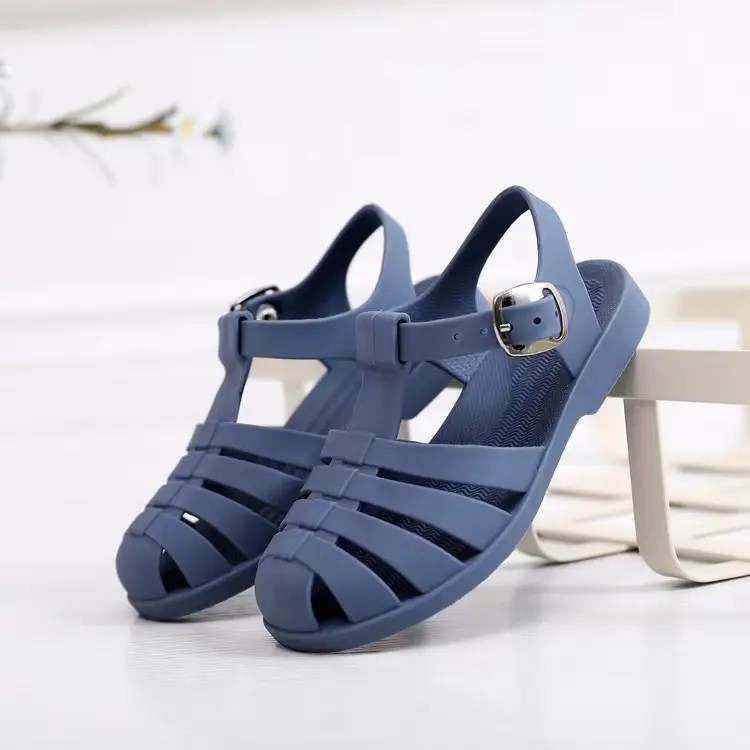 Kids' blue jelly sandals with buckled ankle strap and molded cross straps