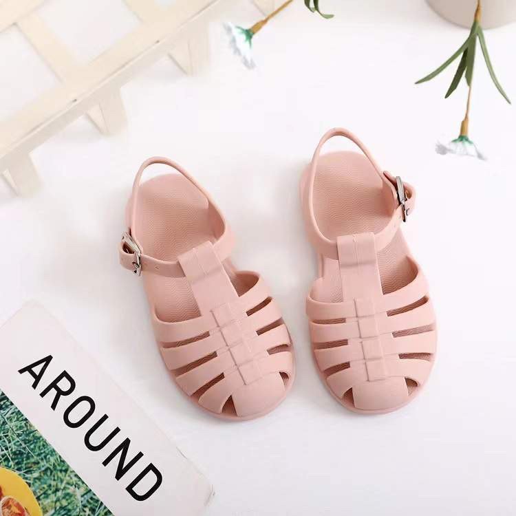 Kids' light pink jelly sandals pair with wide toe straps and buckled ankle