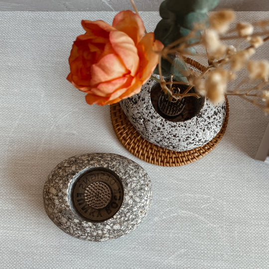 Speckled stone ikebana vase with circular opening and brass-like insert detail
