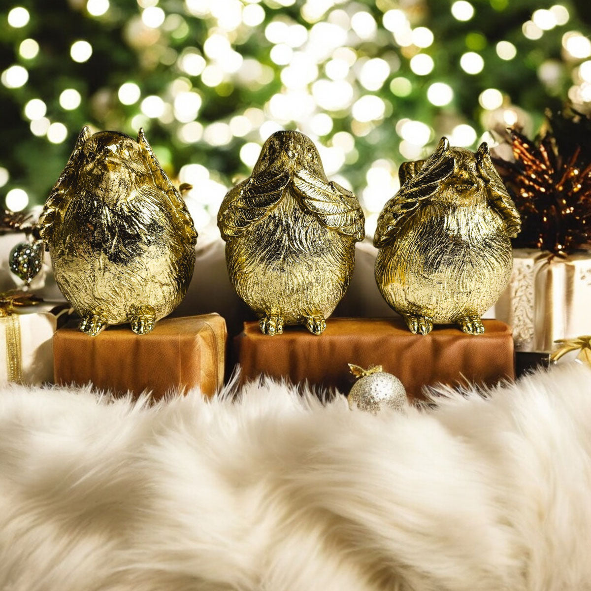 Set of three golden wise bird figurines on wooden blocks with faux fur base.