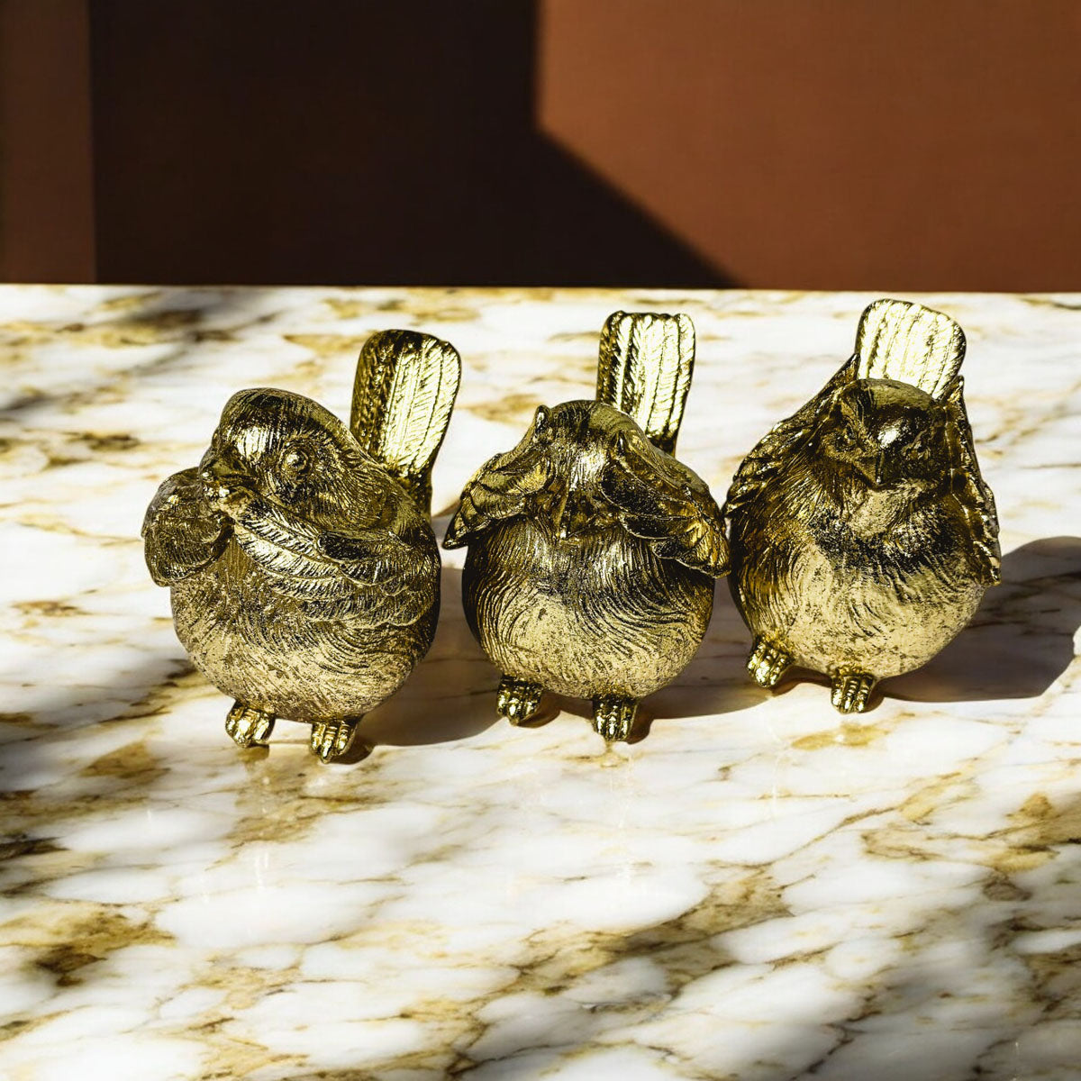 Set of three gold-tone wise bird figurines with open beaks