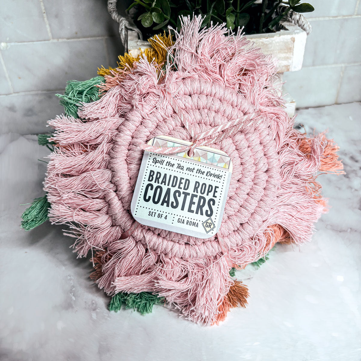 Braided rope tassel coasters set in pink and green with braided spiral and fringe tassels
