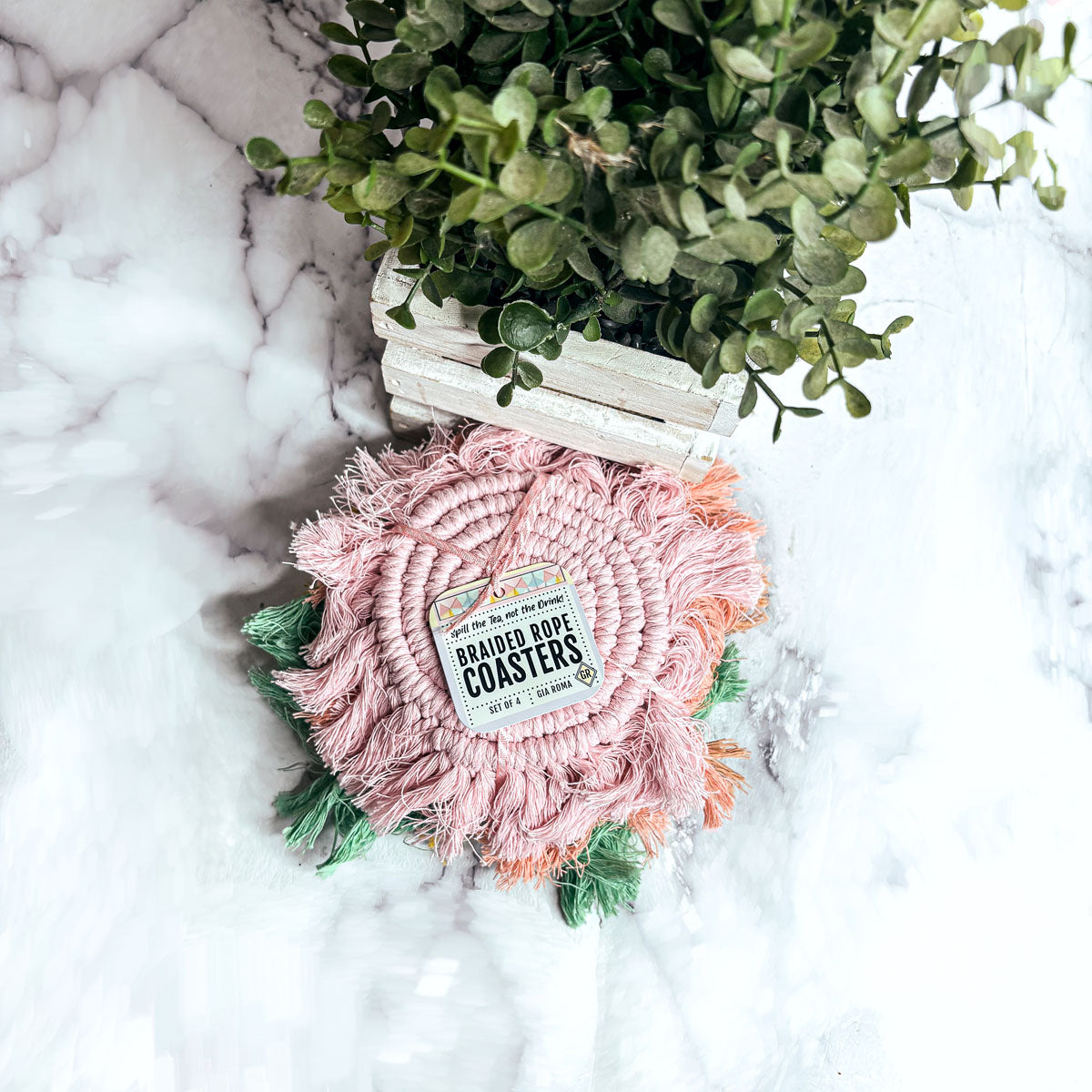 Round pink braided rope coaster with fringed tassels and spiral center