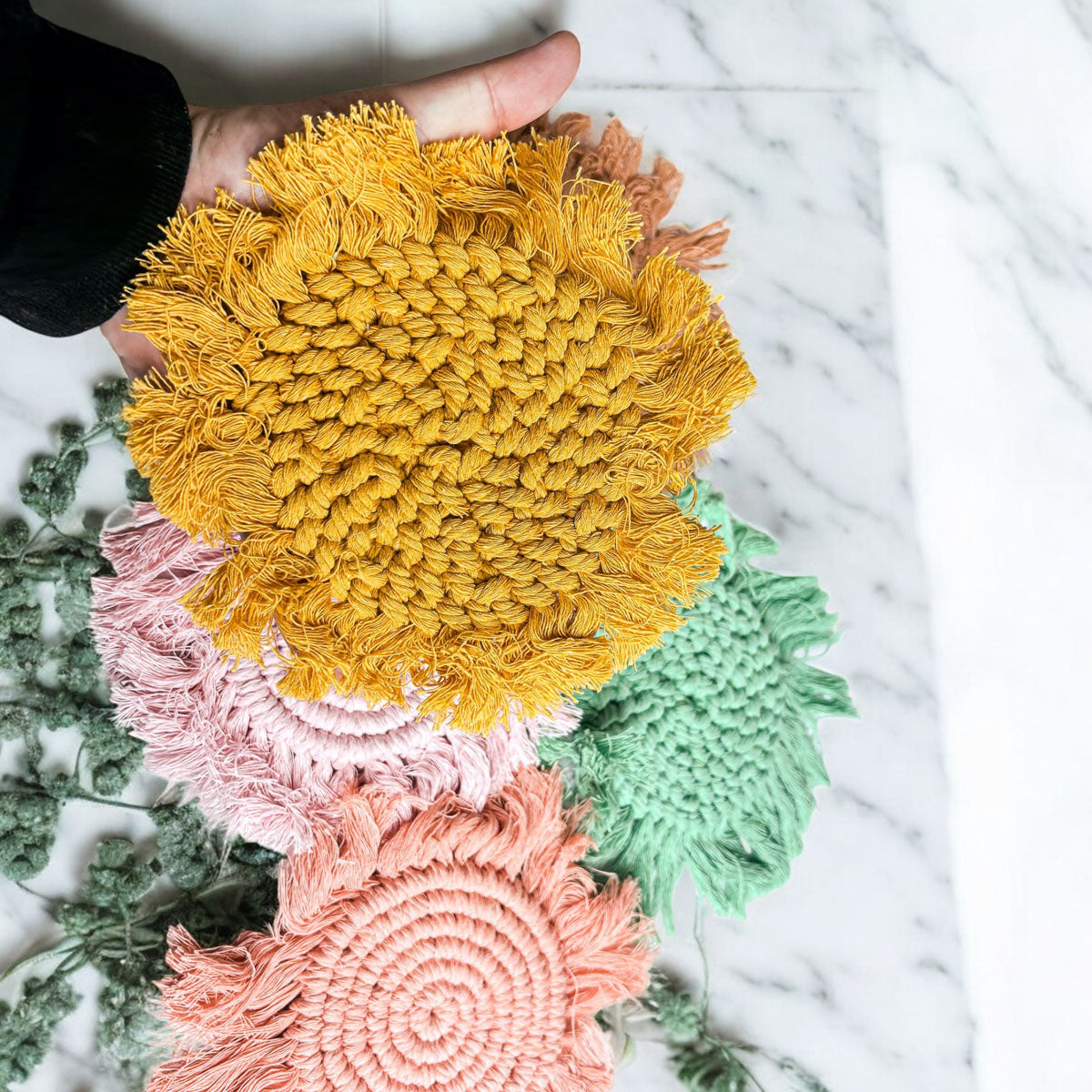 Braided rope tassel coasters in yellow, pink, green, and brown, round woven set