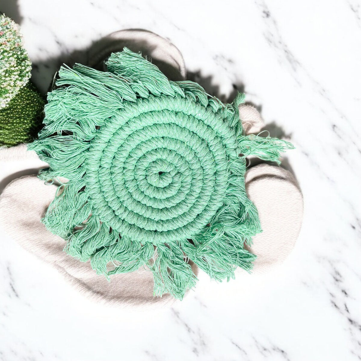 Braided rope tassel coaster in mint green with braided spiral pattern and fringe tassels