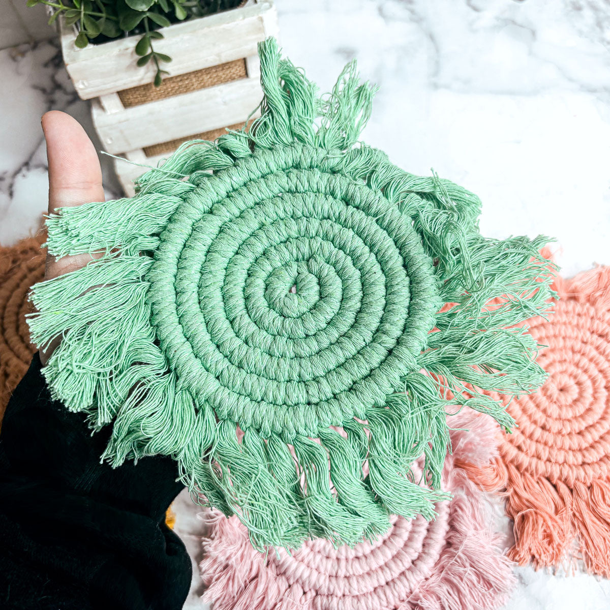 Mint green round braided rope coaster with fringed tassels and spiral center