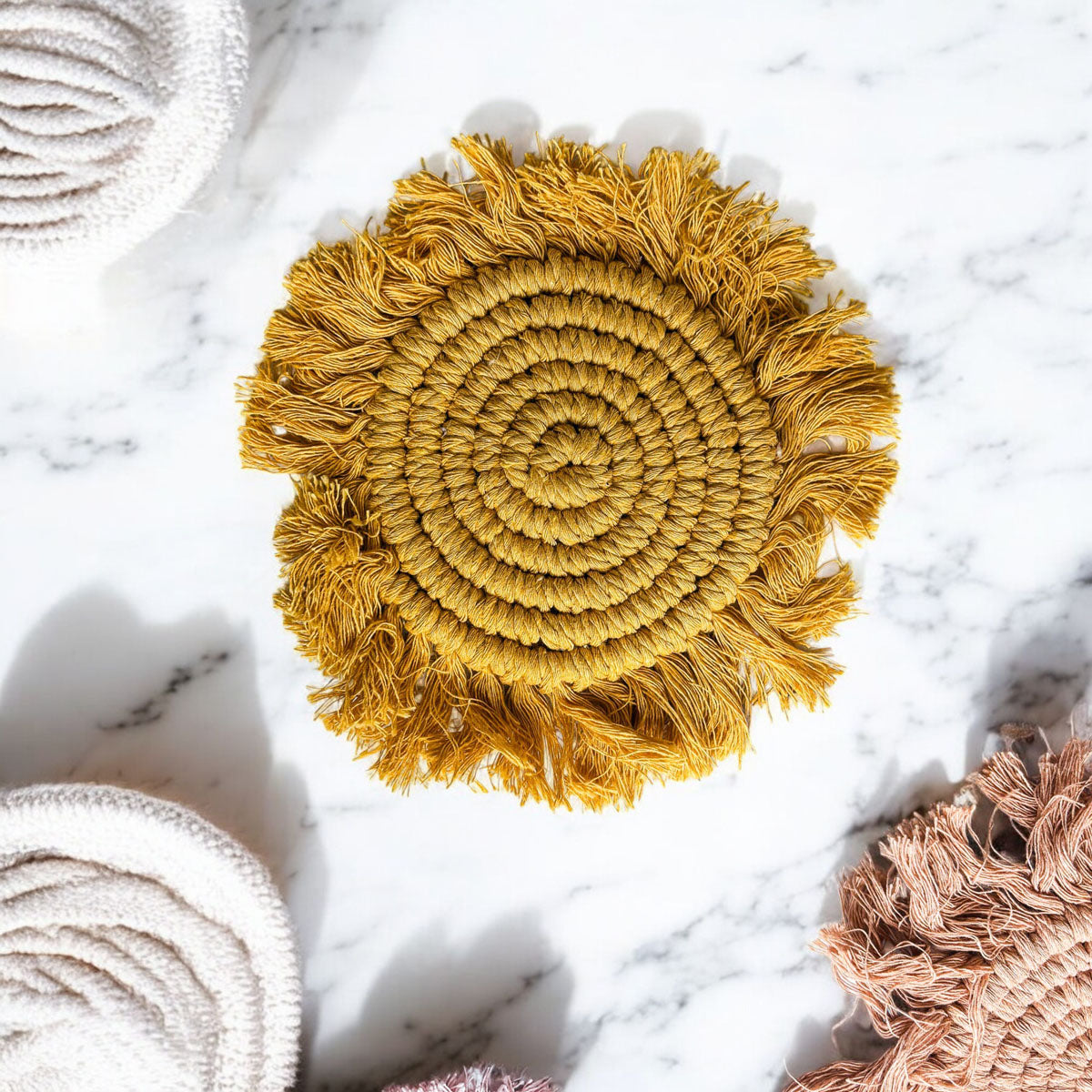 Round braided rope tassel coaster in golden yellow with braided spiral and fringe tassels